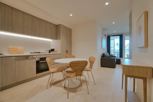 a kitchen and living room with a table and chairs at City Escape at Rundle Mall - Gym & BBQ in Adelaide