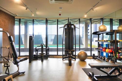 a gym with exercise equipment in a room with windows at City Escape at Rundle Mall - Gym & BBQ in Adelaide
