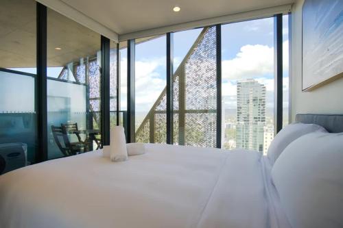 a bedroom with a white bed and a large window at City Escape at Rundle Mall - Gym & BBQ in Adelaide