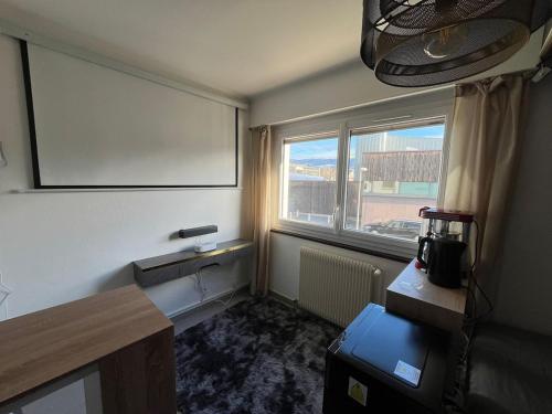 une chambre vide avec une grande fenêtre et un tableau blanc dans l'établissement Pop corn Palace, à Annemasse