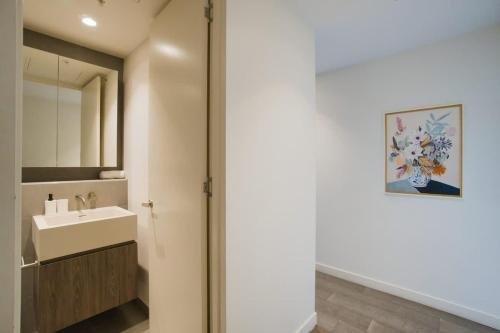 a bathroom with a sink and a mirror at Paradise 2BR Apt in Rundle Mall in Adelaide