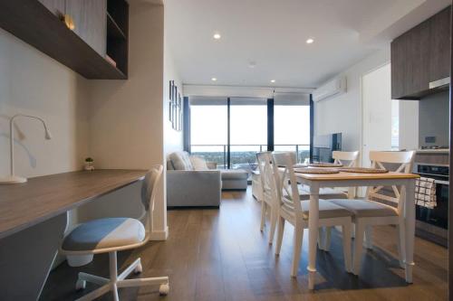 a kitchen and dining room with a table and chairs at Paradise 2BR Apt in Rundle Mall in Adelaide