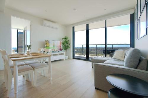 a living room with a table and a couch at Serenity in the Sky - 2BR Apt in Rundle Mall in Adelaide