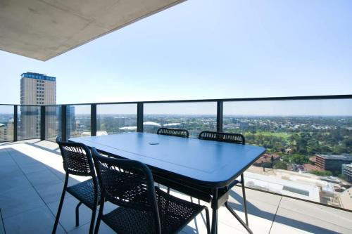 a table and chairs on the balcony of a building at Serenity in the Sky - 2BR Apt in Rundle Mall in Adelaide