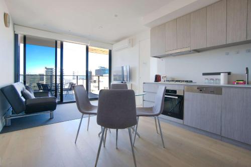 a kitchen with a table and chairs in a room at Rundle Retreat - 2BR Apartment with stunning views in Adelaide