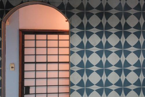 a room with a door and a wall with black and white tiles at KARASUYA GuestHouse in Takasaki