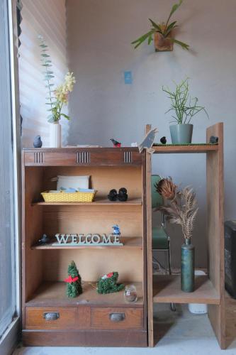 a wooden shelf with potted plants on top of it at KARASUYA GuestHouse in Takasaki