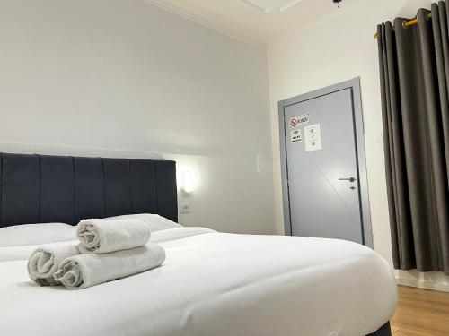a bedroom with a white bed with towels on it at Tirana Square Hotel in Tirana