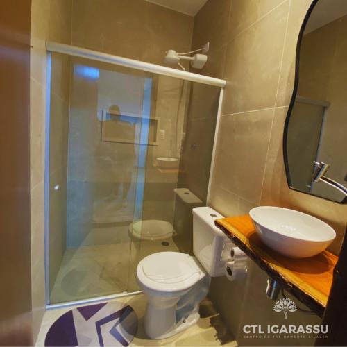 a bathroom with a shower and a toilet and a sink at Pousada CTL Igarassu in Igarassu