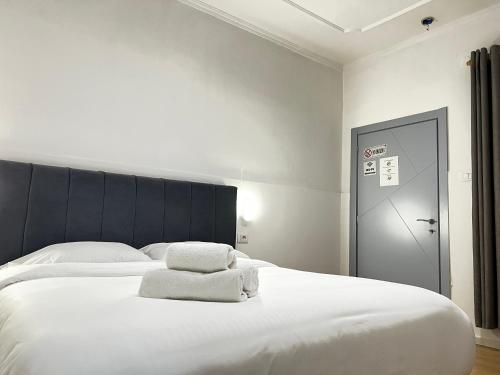 a bedroom with a large white bed with towels on it at Tirana Square Hotel in Tirana