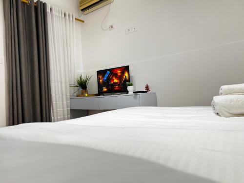 a bedroom with a white bed and a tv at Tirana Square Hotel in Tirana