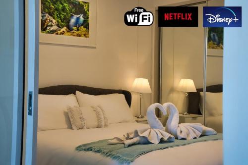 a bedroom with a bed with swans towels on it at Central Escape @ Adelaide CBD in Adelaide