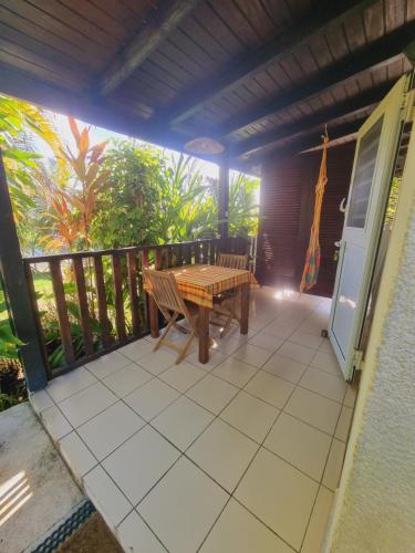 a patio with a wooden table and bench on a deck at Gites Kaladja in Port-Louis