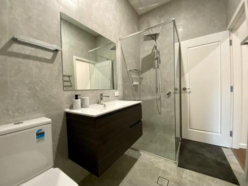 a bathroom with a sink and a shower and a toilet at New Spacious Luxury 5 Bedroom Mansion in Unley in Unley