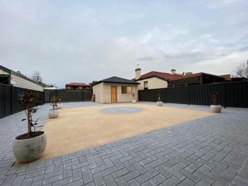 a large courtyard with a house and a fence at New Spacious Luxury 5 Bedroom Mansion in Unley in Unley