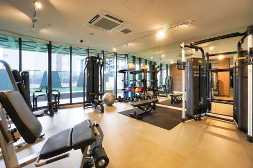 a gym with treadmills and machines in a room at Nintendo Theme-Adelaide CBD-King Bed-Gym-BBQ in Adelaide