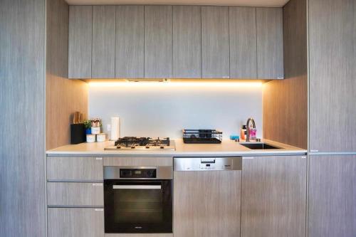 a kitchen with a stove and a counter top at Nintendo Theme-Adelaide CBD-King Bed-Gym-BBQ in Adelaide