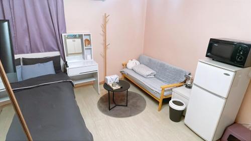 a small room with a couch and a tv at Ellen House in Seoul