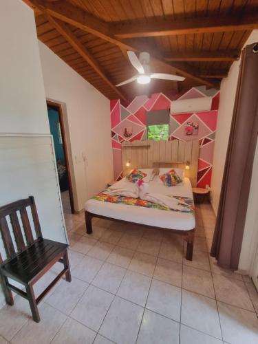 a bedroom with a bed and a chair in a room at Gites Kaladja in Port-Louis