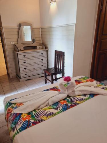 a bedroom with a bed with towels and a dresser at Gites Kaladja in Port-Louis