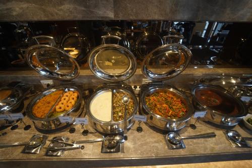 a bunch of pots filled with different types of food at Best Western Swaran Amritsar in Amritsar