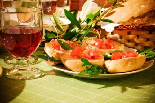 a plate of sandwiches on a table with a glass of wine at Trulli Magravì - Apparthotel in Alberobello