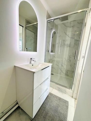 une salle de bain blanche avec un lavabo et une douche dans l'établissement République rue des bluets Paris, à Paris