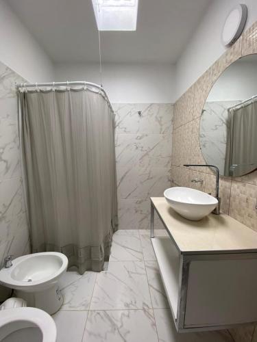 a bathroom with a sink and a toilet and a shower at Cabañas Vicentico in Mina Clavero