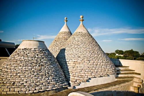 a group of three stone towers with a sky background at Trulli Magravì - Apparthotel in Alberobello