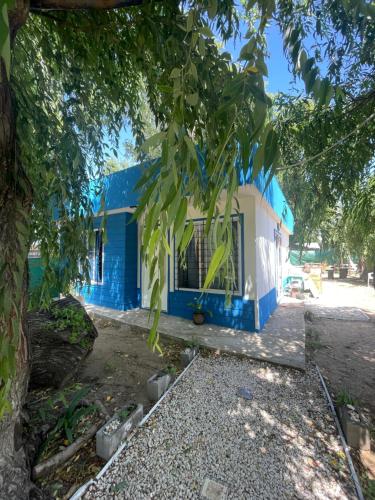 a blue and white house with a tree at Casa de Playa Mar de Ajo Castelli 1257 Beach House in Mar de Ajó
