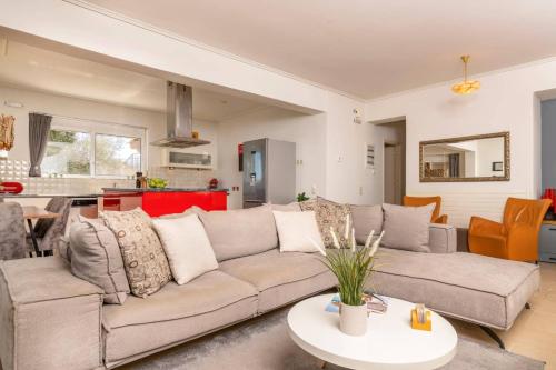 a living room with a couch and a table at Villa Gisele by Villa Plus in Tragaki
