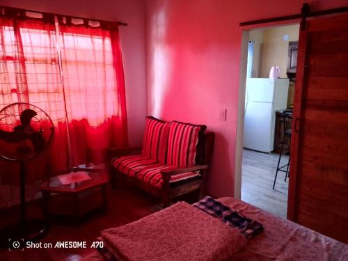 Sala de estar de color rojo con sofá y silla en Lo de tina, en Florencio Varela