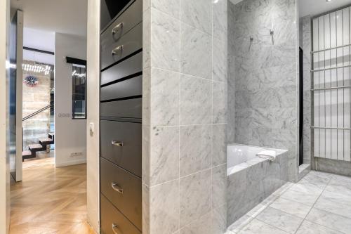 une salle de bain avec une douche à l'italienne et un lavabo dans l'établissement Beautiful loft 130m2 Louvre Palais Royal - II, à Paris