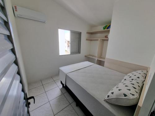 a small room with a bed and a window at Residencial do Angelo - Pinheira in Pinheira