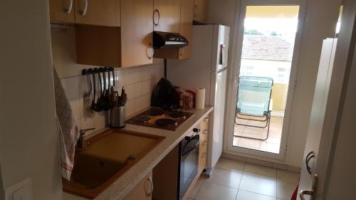 une petite cuisine avec un évier et un réfrigérateur dans l'établissement Chambre pour appartement 51m2 avec grande terrasse, à Nice
