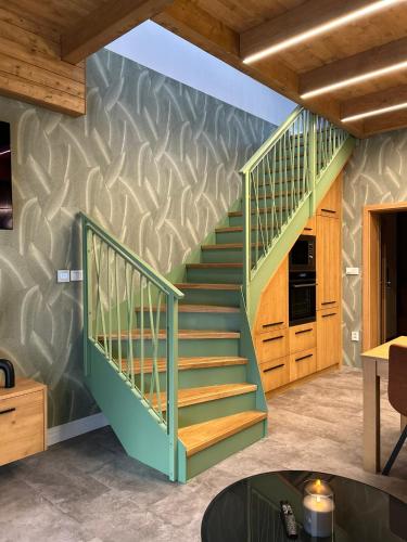 a green staircase in a room with a kitchen at Luxusní Apartmány Domovjanka - LYSÁ HORA, SMRK, KMÍNEK, SLAVÍČ in Bílá