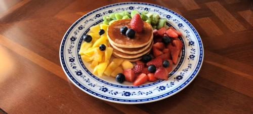 a plate of pancakes and fruit on a wooden table at La Residenza del Marchesato in Marano Marchesato