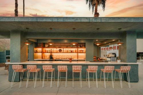 a bar with stools in front of a kitchen at Royal Sun Palm Springs in Palm Springs