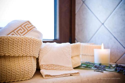 a candle and pillows on a couch next to a window at Trulli Magravì - Apparthotel in Alberobello