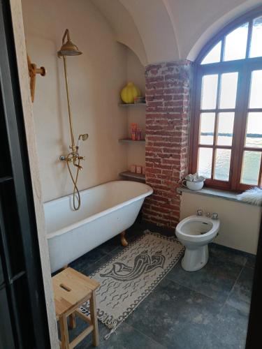 a bathroom with a white tub and a toilet at BugyGattolo in Boves