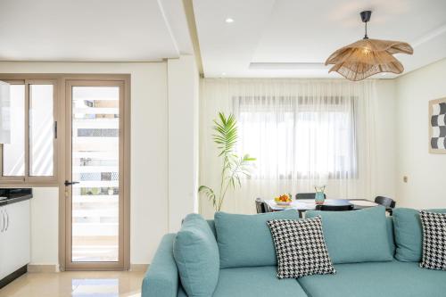 a living room with a blue couch and a table at Very Charming Apartments with balcony, Haut Agdal in Rabat