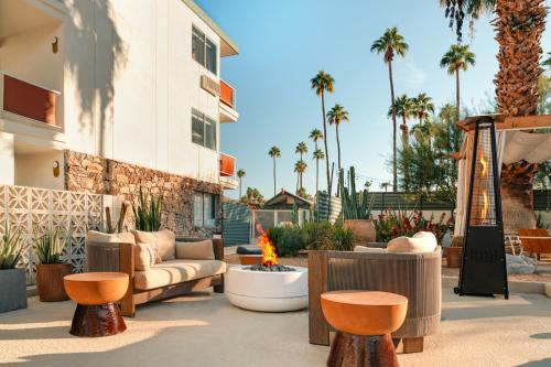 a patio with a couch and chairs and a fire pit at Royal Sun Palm Springs in Palm Springs