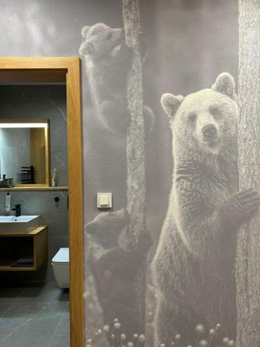 a mural of a bear on the wall of a bathroom at Luxusní Apartmány Domovjanka - LYSÁ HORA, SMRK, KMÍNEK, SLAVÍČ in Bílá