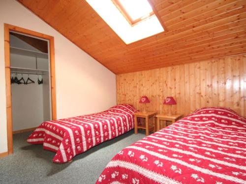 two beds in a room with red and white sheets at Appartement 4 pièces, 8 pers., proche centre et remontées, animaux admis, parking, WiFi - FR-1-676-103 in Châtel