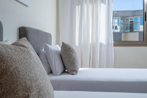 a bedroom with a bed with pillows and a window at Very Charming Apartments with balcony, Haut Agdal in Rabat