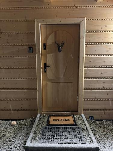a door with a welcome sign in front of it at Chata na Wzgórzu in Ochotnica Dolna