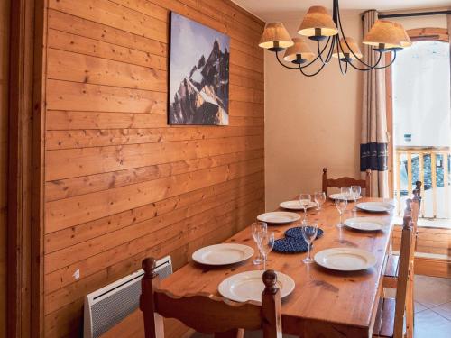 une salle à manger en bois avec une table en bois et des chaises dans l'établissement Chalet confortable à Val Thorens, 50m des pistes, 8 pers., cheminée, parking, local à skis - FR-1-637-80, à Val Thorens