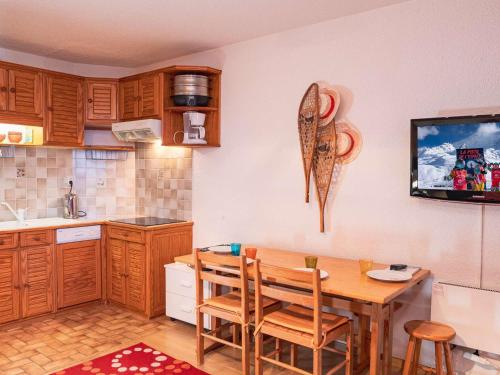 Il comprend une cuisine avec une table et une télévision murale. dans l'établissement Appartement confortable à Val Thorens - 4 pers - Balcon - Proche pistes - FR-1-637-82, à Val Thorens