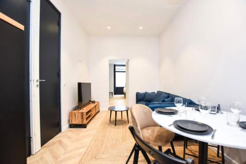 un salon avec une table et un canapé bleu dans l'établissement Gard du Nord - Apartment Cosy 6P, à Paris