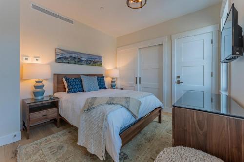 a bedroom with a bed and a flat screen tv at Academy Place | Glacier Lily Penthouse in Crested Butte
